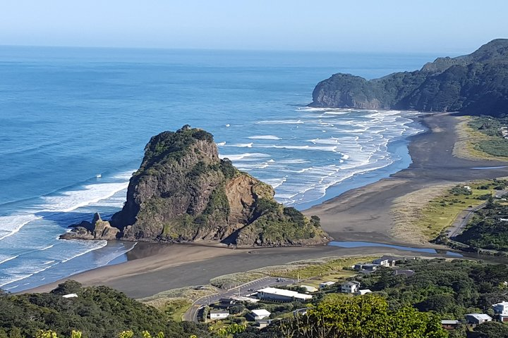 Experience the stunning coastline of Piha Beach where soft black sands meet crashing waves framed by dramatic cliffs and lush rainforest perfect for nature lovers exploring Auckland's hidden gems.